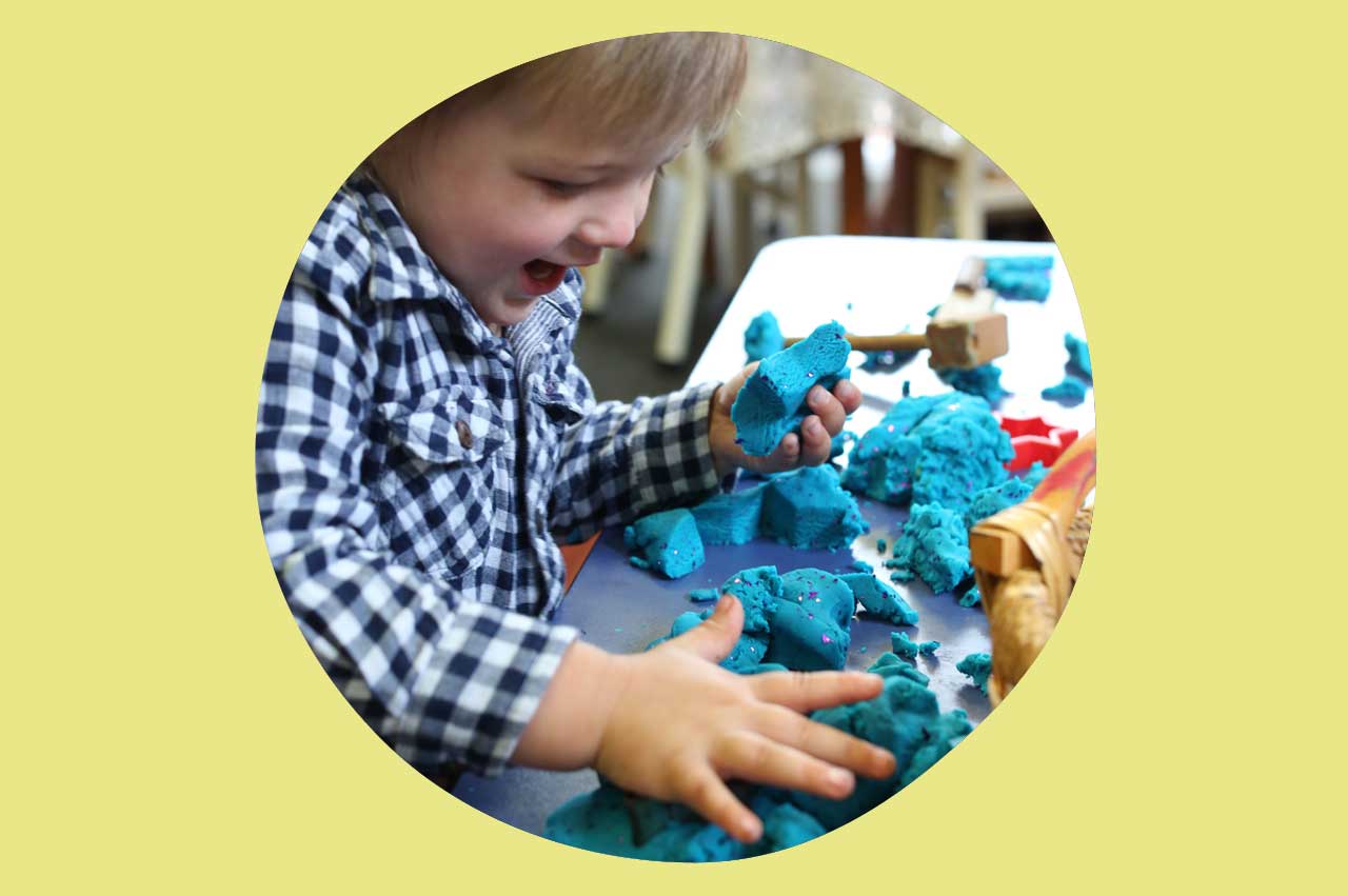 Boy plays with tactile play dough at the play dough table